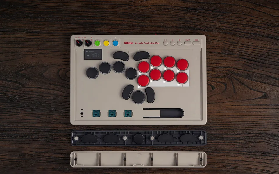 Top view of the Arcade Controller Pro with three spare switches and a switch puller in an inner tray, and the opened wrist rest holding five lock caps below