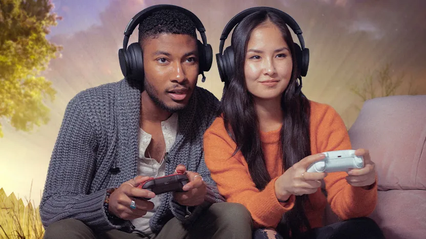 Two players with headsets and Xbox controllers sitting on a couch