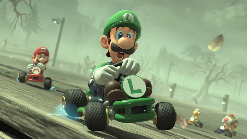 Luigi drives a green kart ahead of Mario on the misty Ghost Valley course in Mario Kart World
