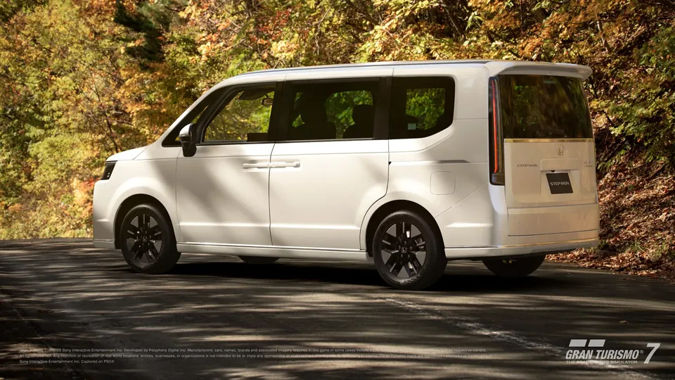 A white Honda Step WGN Spada minivan parked on a forest road lined with autumn trees