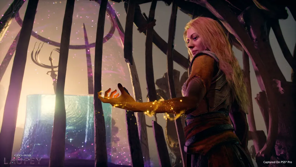 Faye reaches toward a glowing blue cube in God of War Laufey