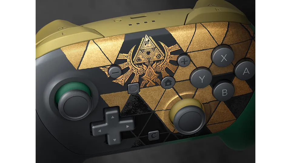A close view of the Zelda Pro Controller's gold triangle pattern and the gold crest topped by the Triforce.