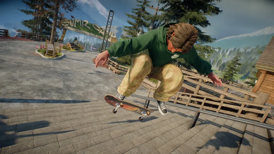 A skater in a green hoodie and baggy tan pants kickflips down stone stairs at the S.U.M.R. Camp mountain park in skate.