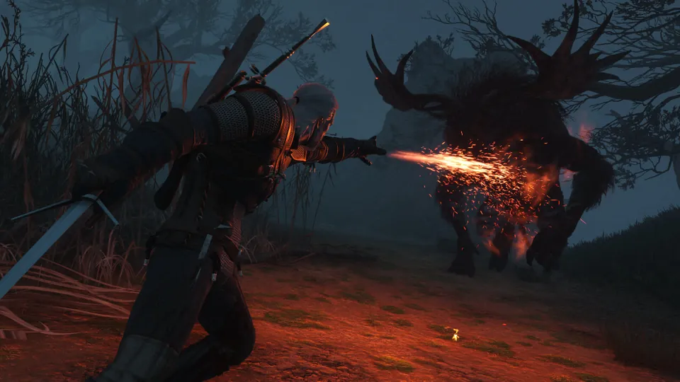 Geralt casts a stream of fire at a tall antlered monster in a dark forest in The Witcher 3 Remastered on Switch 2.