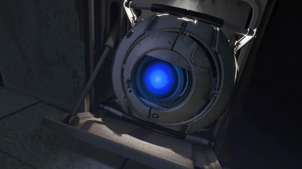 Wheatley, a round robot with a glowing blue eye, peers out of a wall socket in Portal 2