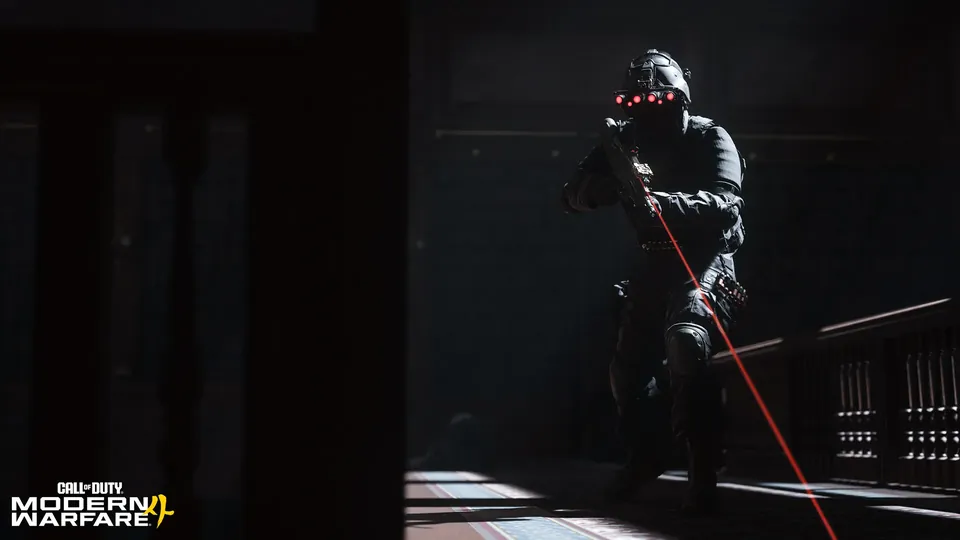 A soldier in night-vision goggles aims a rifle with a red laser down a dark hallway in Call of Duty: Modern Warfare 4