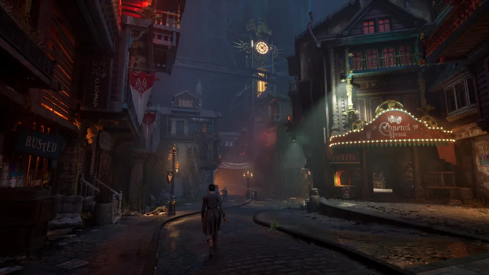 A lone figure walks down a cobbled steampunk street toward a glowing theater, under a tall clock tower at night