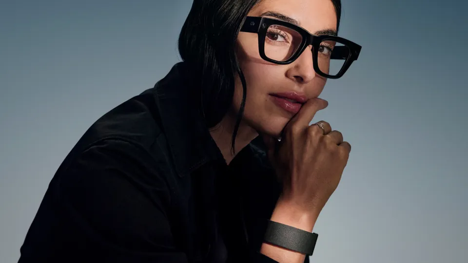 A woman wearing Meta Ray-Ban Display glasses and the Neural Band on her wrist