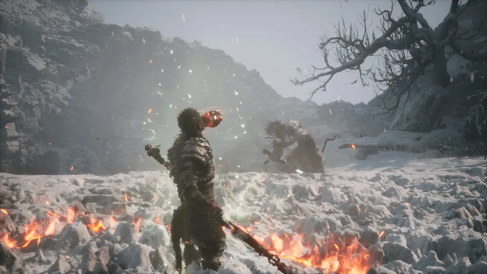 The Destined One stands in a snowy valley with a staff as embers drift around