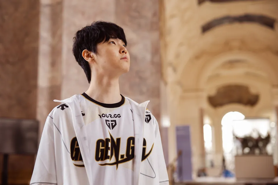 A Gen.G player in a white team jersey looks up inside a marble hall at the Worlds 2024 semifinal photo shoot in Paris