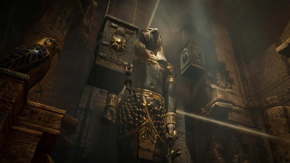 A golden mechanism hangs above a sun disc in a tomb lit by a beam of light in Tomb Raider: Legacy of Atlantis