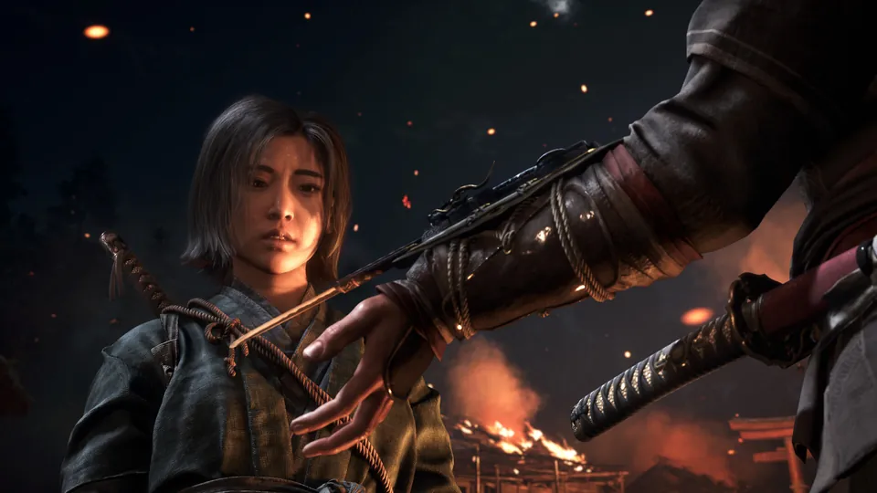 A young shinobi with short dark hair draws a blade in front of burning buildings at night in Assassin's Creed Shadows