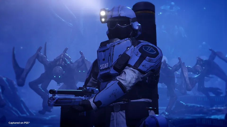 A SEAF soldier with a helmet lamp and a large backpack standing guard in a blue-lit cavern as tall creatures loom behind