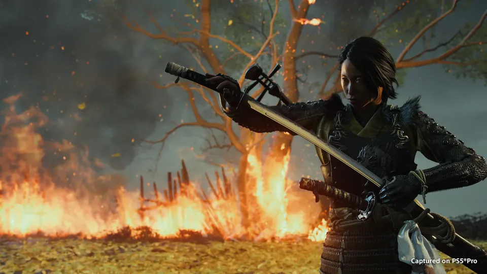Atsu drawing a katana in front of a burning field in Ghost of Yōtei