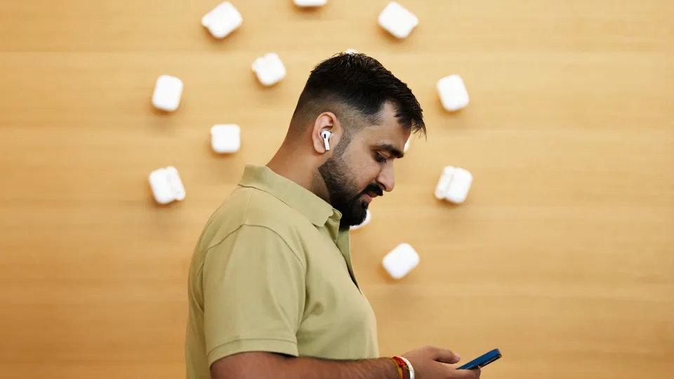 A customer wearing AirPods 5 at Apple BKC in Mumbai