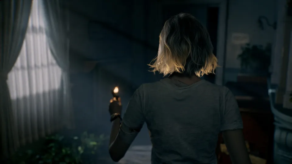 Grace Ashcroft walks through a dark room holding up a lighter toward a curtained window