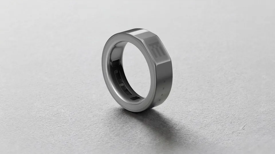 The Even R1 smart ring standing on a grey surface
