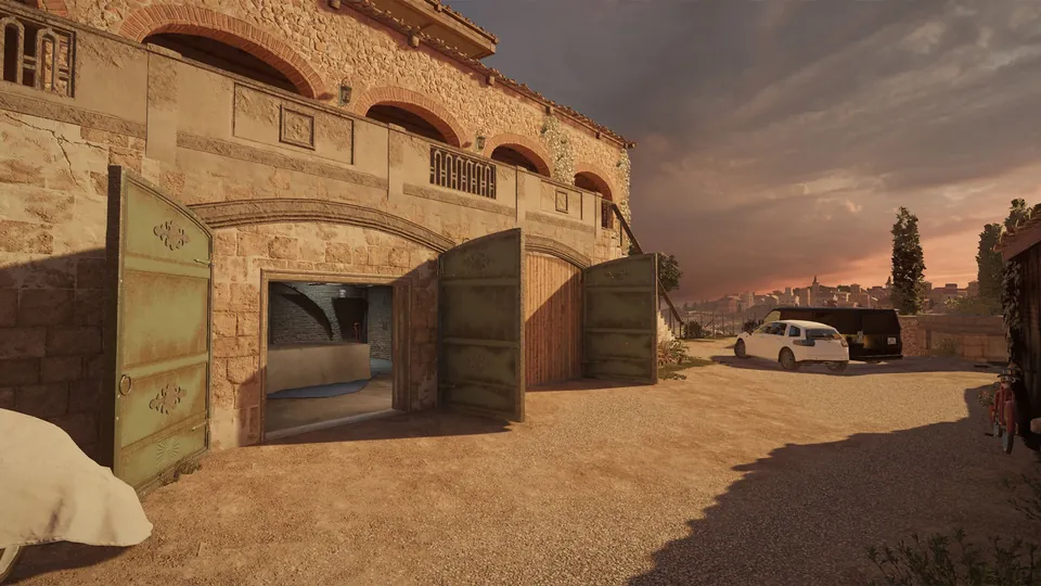 The Villa map in Rainbow Six Siege, a sandstone house with arched windows and open green garage doors facing a gravel courtyard at sunset