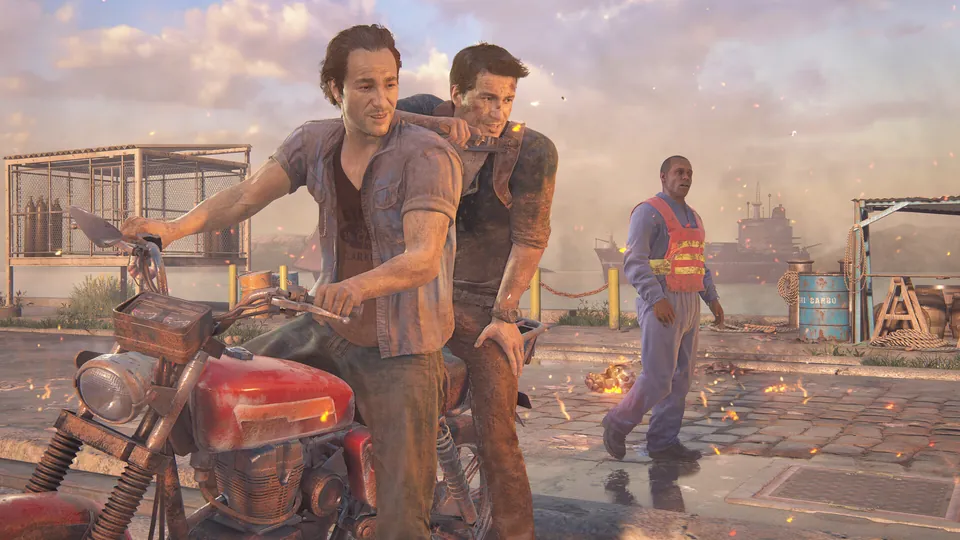 Nathan and Sam Drake ride a red motorcycle along a dock in Uncharted 4: A Thief's End