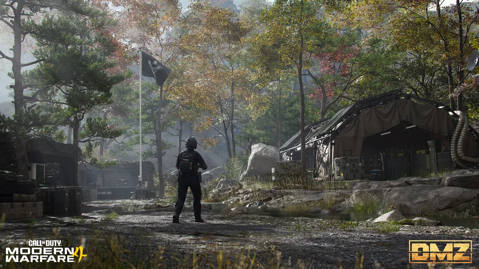 A lone operator at a forest camp with tents and a flag