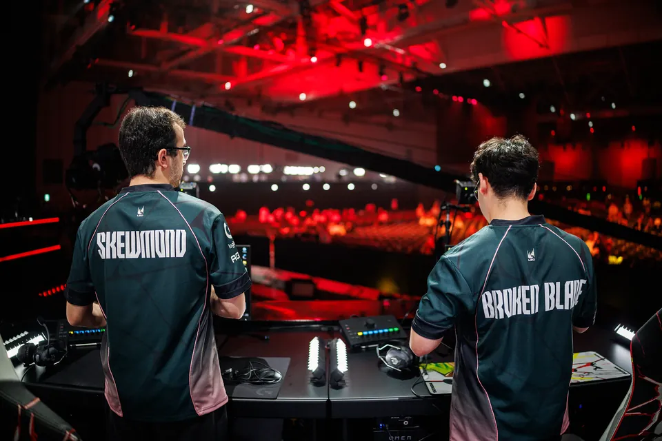 SkewMond and BrokenBlade of G2 Esports set up at the stage desks at MSI 2026, with the arena lit in red