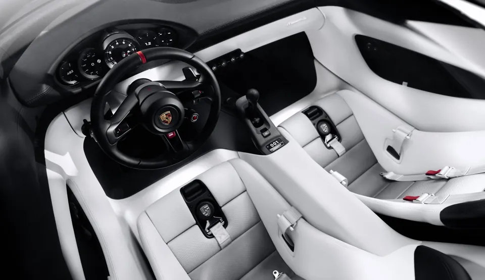 The Porsche Mission S cabin from above, with white seats, a black steering wheel and five round gauges