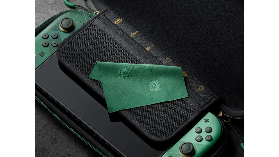 The Zelda carrying case open with a green and gold Switch 2 inside and a green cloth on top.