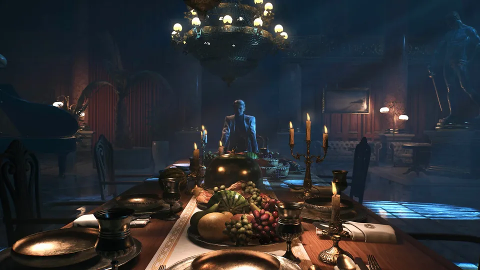 A candlelit mansion dining hall in Dying Light: The Beast, with a long feast table, a chandelier and a lone figure at the far end.