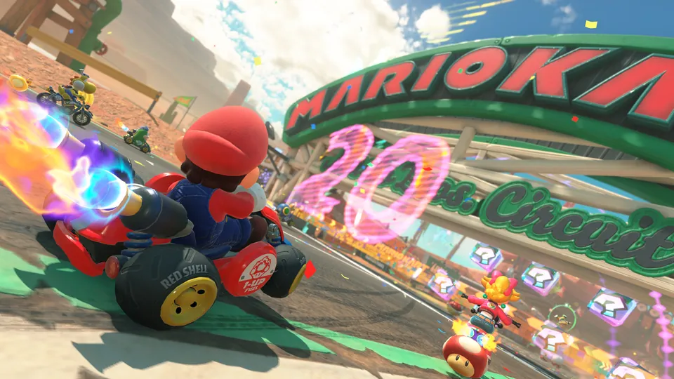 Mario drives a red kart past a big Mario Kart sign and a row of item boxes at Mario Circuit in Mario Kart World