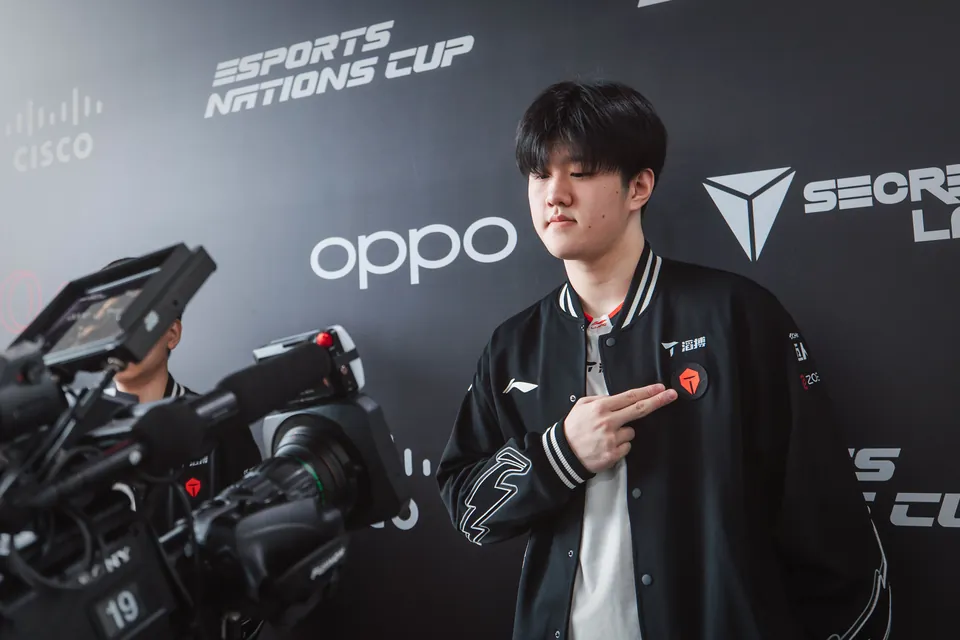 A Top Esports player points to the team logo at the media wall at MSI 2026 in Daejeon, South Korea