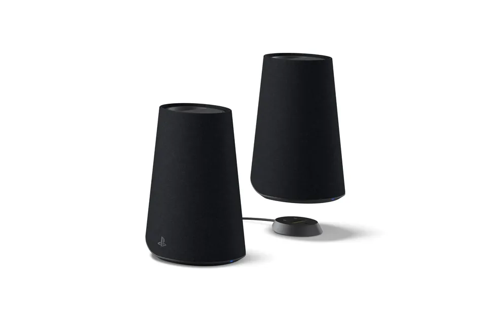 Two Midnight Black Pulse Elevate speakers with a round black charging dock and its cable between them