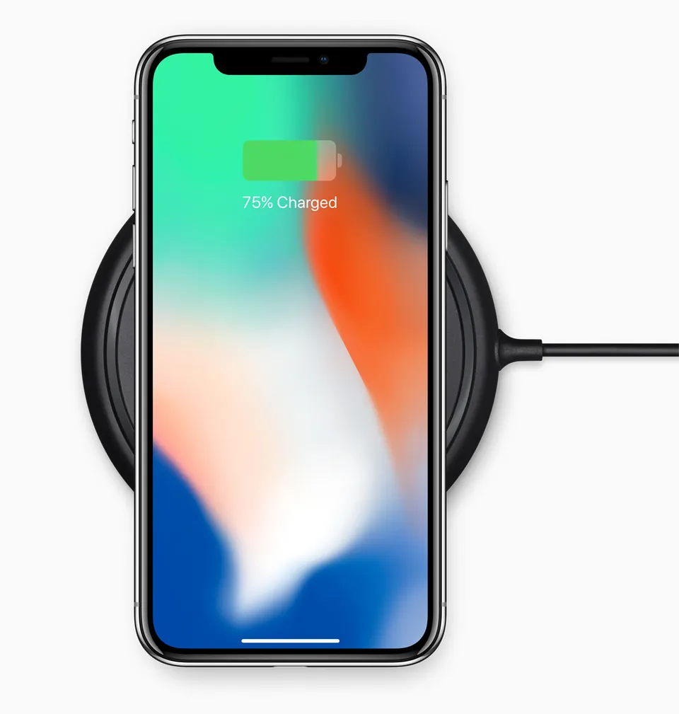 iPhone X on a wireless charging pad, showing 75% charged