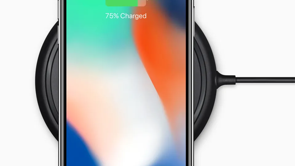 iPhone X on a wireless charging pad, showing 75% charged