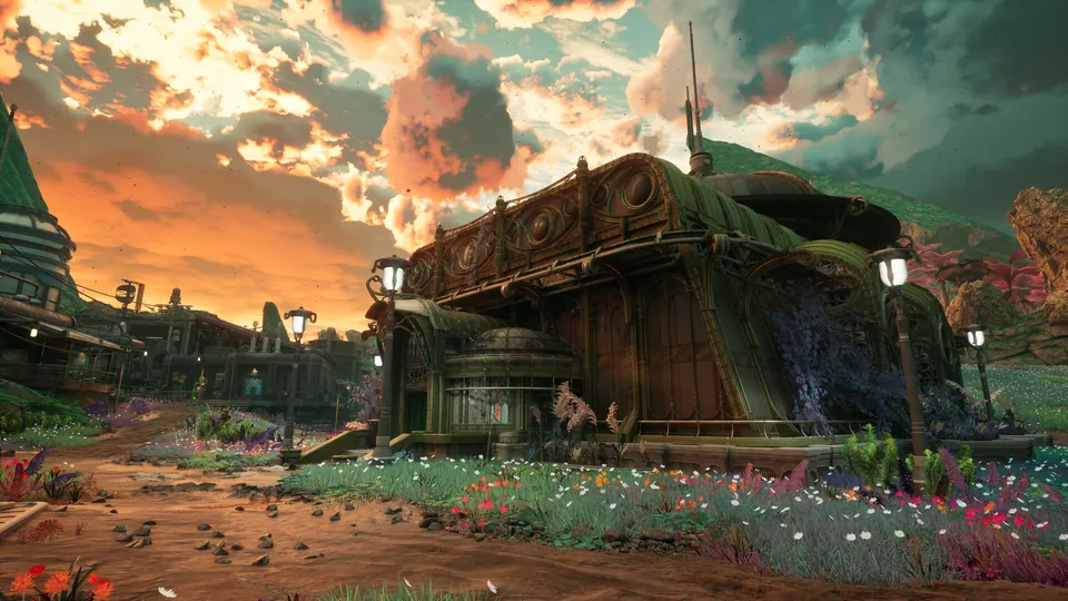 A green-roofed colony building and flower beds under a dramatic sunset sky