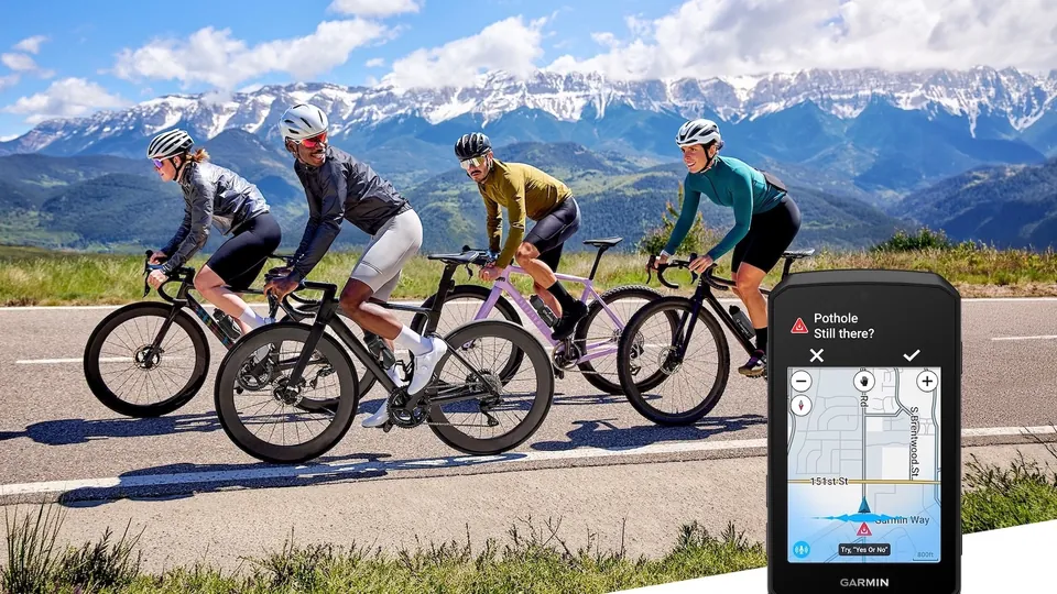 Four cyclists ride road bikes below snowy mountains next to a Garmin Edge 1060 showing a pothole alert on a street map