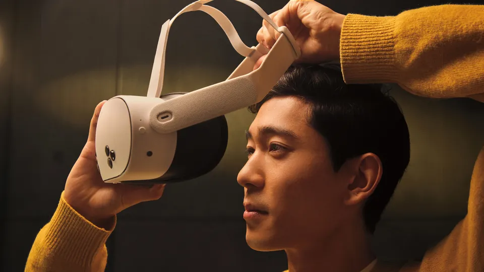 A person putting on a white Meta Quest 3S headset
