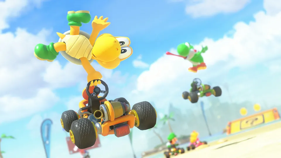 A Koopa Troopa does a midair trick above a kart on the sunny Koopa Beach course in Mario Kart World