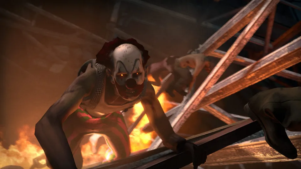 A zombie in clown makeup climbs through burning wreckage in Left 4 Dead 2