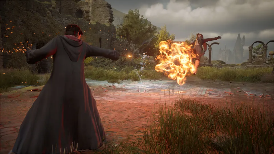 A student in black robes casts a spell as a fireball bursts toward a dark wizard in the ruins in Hogwarts Legacy on Nintendo Switch 2