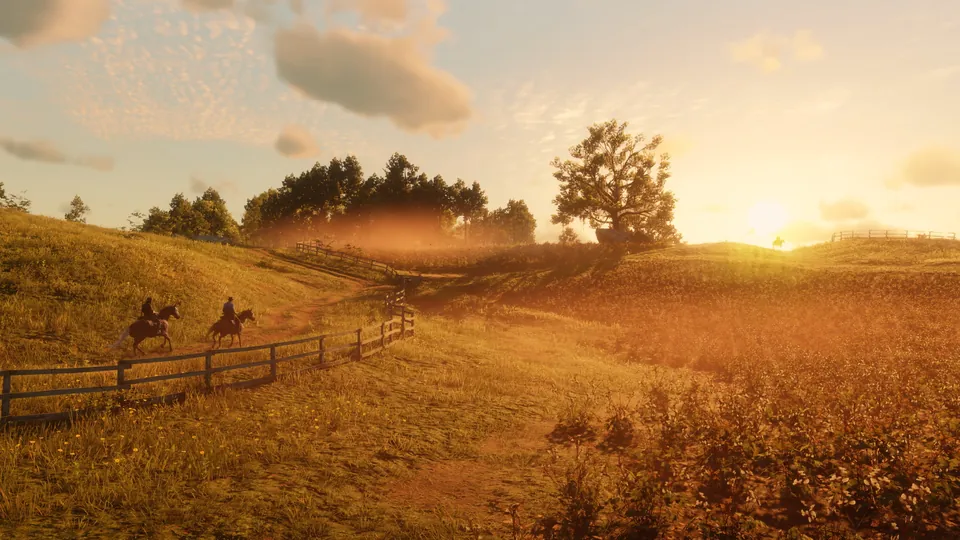 Two riders cross a golden field at sunset past a wooden fence in Red Dead Redemption 2