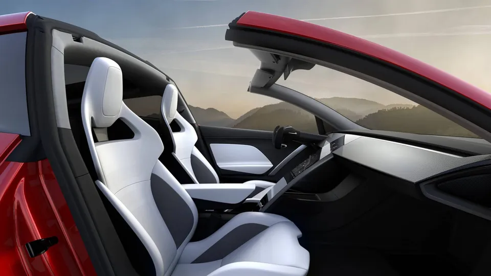 The white front seats and dashboard of a Tesla Roadster prototype with the roof open