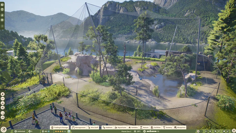 A large mesh-covered aviary built on a mountainside