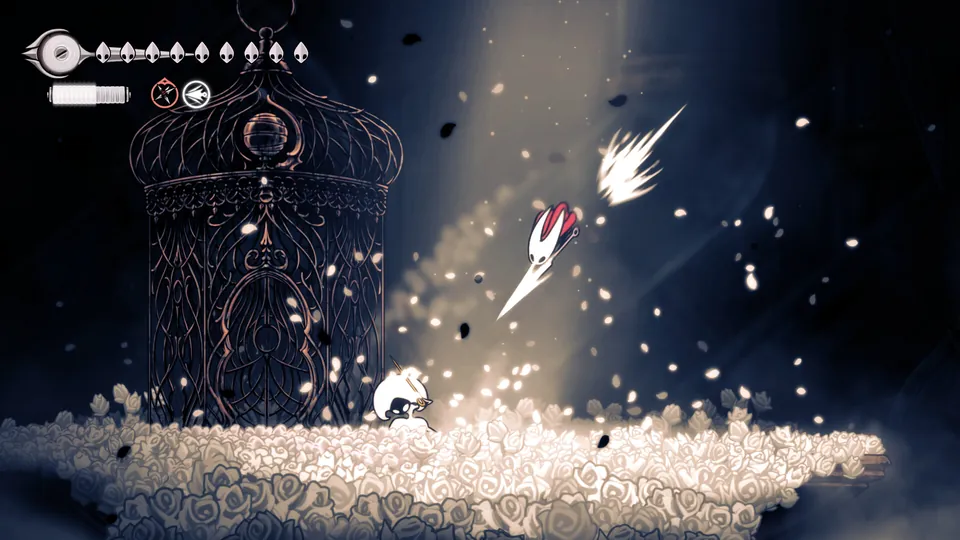Hornet strikes upward in a burst of white petals beside an ornate cage in Hollow Knight: Silksong
