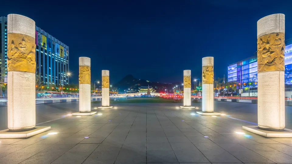 Gwanghwamun Square in Seoul at night, with lit stone pillars, where Riot held its Worlds 2023 fan festival