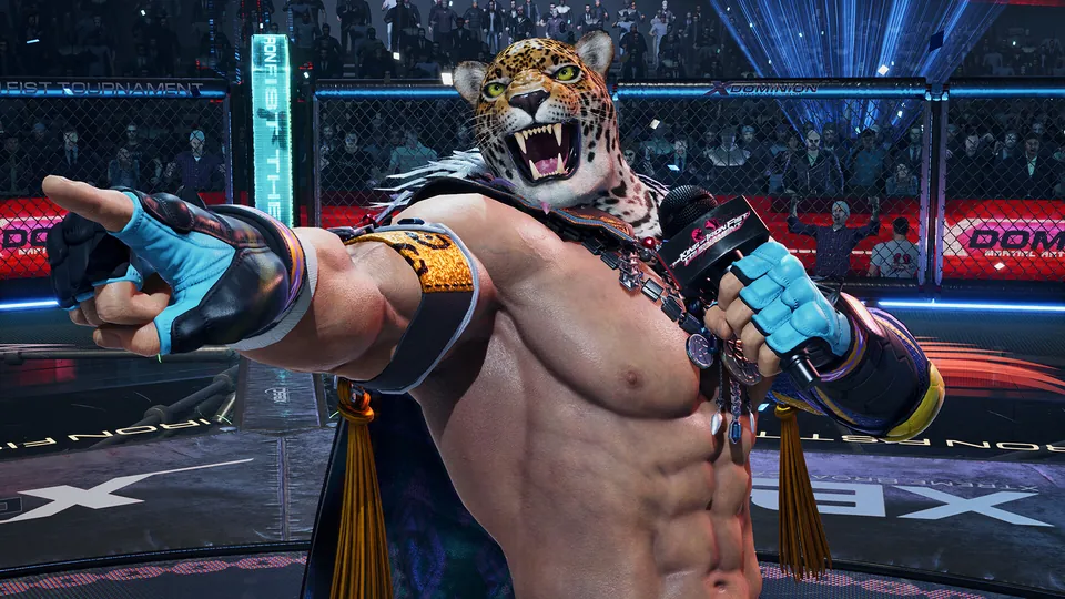 A fighter in a jaguar mask points at the camera in a cage arena with a crowd behind in Tekken 8