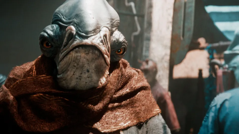 A close-up of an alien in a brown hood in a busy marketplace in Star Wars Eclipse