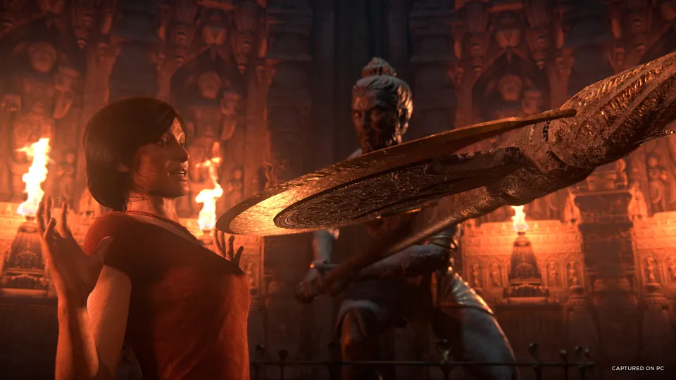 Chloe Frazer in a torch-lit stone temple in Uncharted: The Lost Legacy