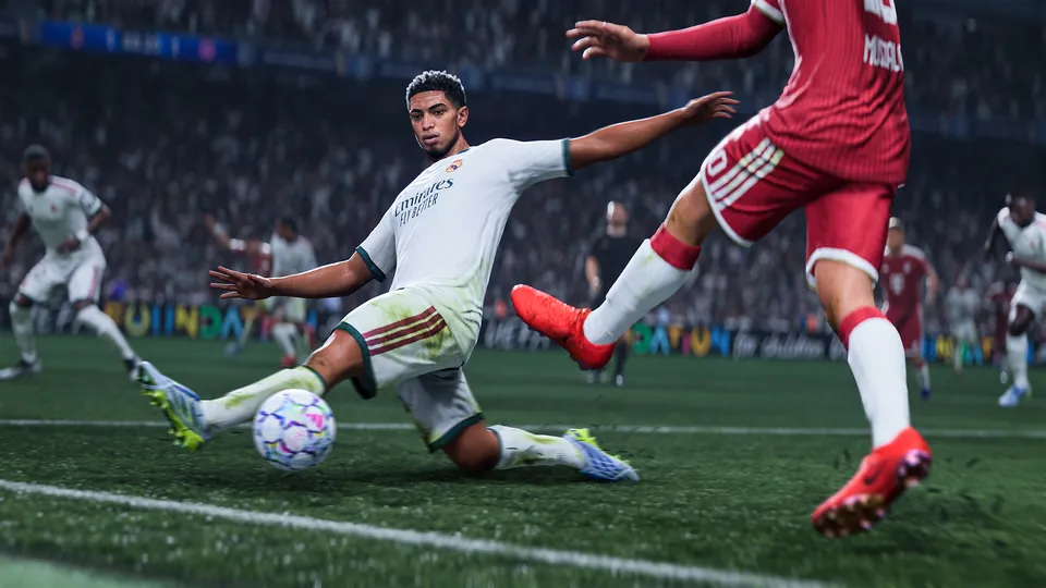A player in a white kit slides in to strike the ball past a defender in red, in EA Sports FC 27 on Switch 2