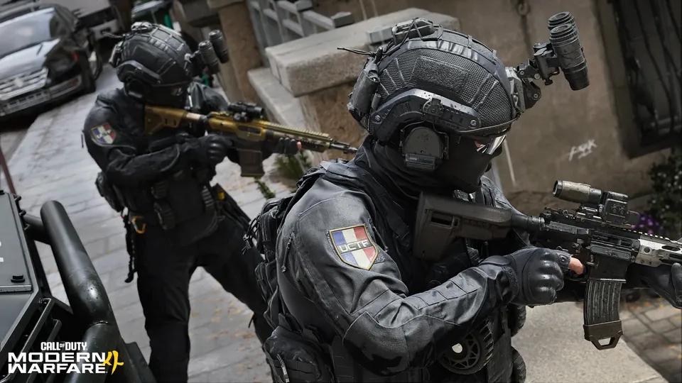 Two special forces soldiers aim rifles inside a building