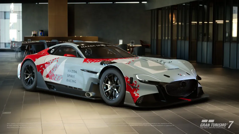 The Mazda RX-Vision GT3 Evo race car in a red and white livery inside a modern showroom
